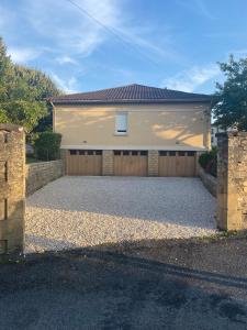 a house with a garage with a driveway at T3 Neuf, parking & garage privé, proche centre in Sarlat-la-Canéda