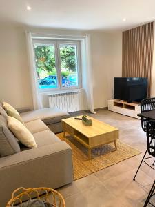 a living room with a couch and a coffee table at T3 Neuf, parking & garage privé, proche centre in Sarlat-la-Canéda