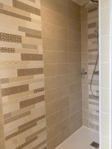 een badkamer met een douche met beige tegels bij T3 Neuf, parking & garage privé, proche centre in Sarlat-la-Canéda