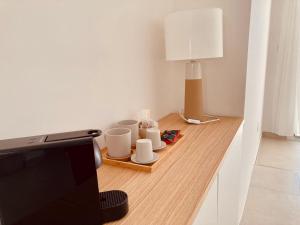 a room with a table with cups and a television at Puerto Escondido in Castro di Lecce