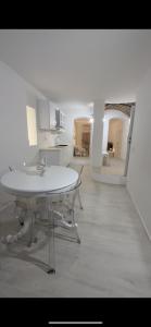 una camera bianca con tavolo bianco e cucina di Giglio di mare a Tropea