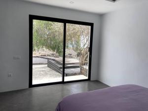 1 dormitorio con una gran puerta de cristal que da a un patio en Cosy finca, sea views, jacuzzi, en La Asomada 16 fotos más