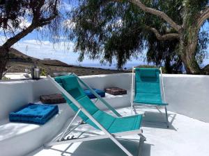 dos sillas sentadas sobre una mesa en Cosy finca, sea views, jacuzzi, en La Asomada