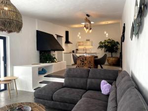 Una sala de estar con un sofá y una cocina. en Cosy finca, sea views, jacuzzi, en La Asomada