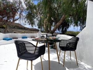 Una mesa y sillas en un patio. en Cosy finca, sea views, jacuzzi, en La Asomada