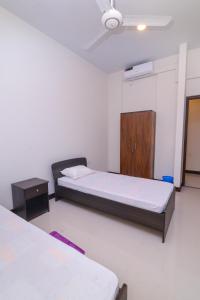 a bedroom with two beds and a wooden cabinet at Bluewind Luxury Apartment - 2rooms - Wattala-Hemas Hospital in Wattala