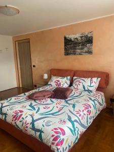 a bed with a colorful comforter in a bedroom at Chez Carlo 2.0 in Aosta