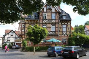 duży dom z samochodami zaparkowanymi przed nim w obiekcie Hotel Alte Post w mieście Bad Sooden-Allendorf