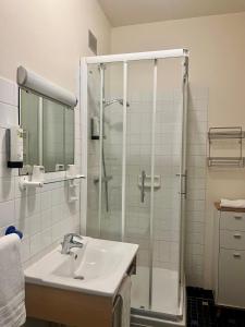 a bathroom with a glass shower and a sink at Le Relais de la route bleue in Saint-Loup