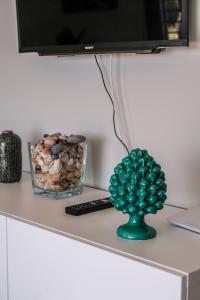 eine grüne Vase auf einem Schreibtisch mit einem TV in der Unterkunft Isola Bella Luxury View in Taormina