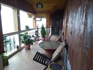 uma varanda com uma mesa e vasos de plantas em Vamoose Manali Beach Resort em Bhogwe