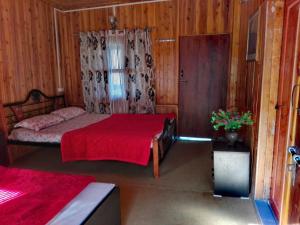 a bedroom with a bed with a red blanket at Vamoose Manali Beach Resort in Bhogwe