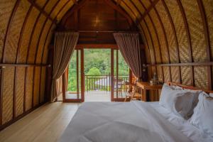 a bedroom with a bed in a room with a window at Lumbung Seraya Villa in Karangasem