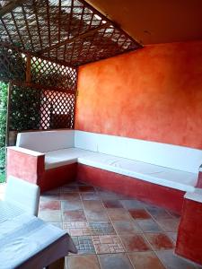 a bench in a room with an orange wall at Appartamento Salina Bamba in San Teodoro