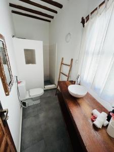 a bathroom with a sink and two toilets at MITI Beach Bungalows in Nungwi