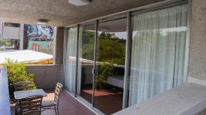 einen Balkon mit Glastüren sowie einem Tisch und Stühlen in der Unterkunft Suites Las Plazas in Cuernavaca