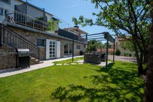 a backyard with a barbecue grill in a yard at Apartman Noa in Kastav