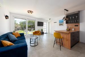 a living room with a blue couch and a kitchen at Apartman Noa in Kastav