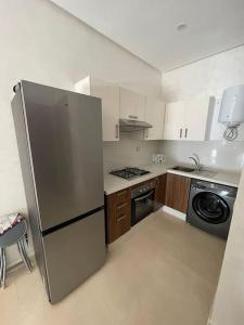 una cocina con frigorífico de acero inoxidable y lavavajillas en Résidence COSTA BEACH 3 IMMEUBLE 10 APPT 1 Bouzinka, en Bouznika 4 fotos más