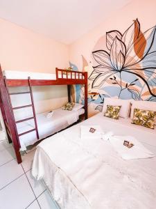 2 Betten in einem Zimmer mit Wandbild in der Unterkunft Nirvana Pipa in Pipa