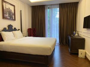 a hotel room with a bed and a large window at Feliz Hotel Binh Duong in Thu Dau Mot