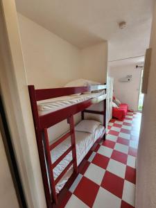 Łóżko piętrowe w pokoju z podłogą wyłożoną szachownicą w obiekcie Studio cabine + Parking : proche plage w mieście Canet-en-Roussillon