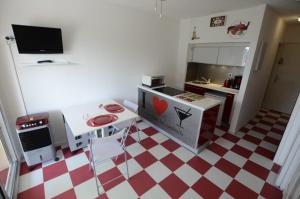 uma pequena cozinha com piso xadrez vermelho e branco em Studio cabine + Parking : proche plage em Canet-en-Roussillon