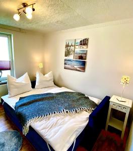 - une chambre avec un lit doté d'une couverture bleue dans l'établissement Gemütliche Ferienwohnung, à Sagard