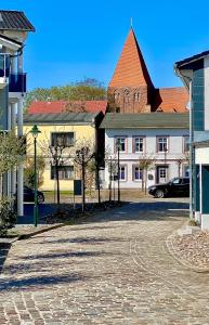 une rue dans une ville avec une église et un bâtiment dans l'établissement Gemütliche Ferienwohnung, à Sagard