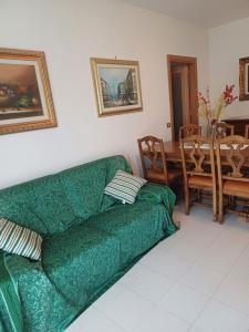 - un canapé vert dans le salon avec une table dans l'établissement La terrazza, à Tuoro sul Trasimeno