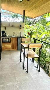 uma cozinha com uma mesa e um banco num pátio em Sharma Costa Rica - Heliconia Casita em Uvita