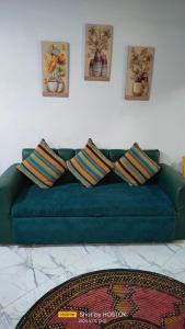 a green couch in a living room with three pillows at Porto said in Port Said