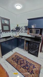 una cucina con forno a microonde e bancone con tappeto di Porto said a Port Said