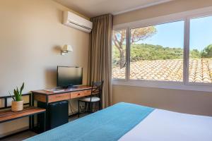a hotel room with a bed and a desk and a window at Hotel Hostalillo by Escampa Hotels in Tamariu