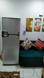 a refrigerator in a living room with a green couch at Porto said in Port Said