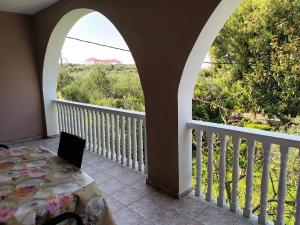 einen Balkon mit einem Torbogen, einem Tisch und Aussicht in der Unterkunft Oasis in Ammoudi