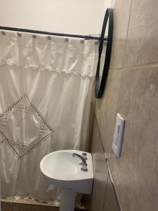 a bathroom with a sink and a shower curtain at Departamentos Cristo del Portezuelo in Chilecito