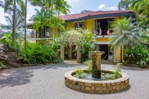 een geel huis met een fontein ervoor bij Bougainvillea Retreat in Kandy