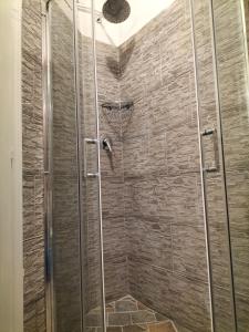 y baño con ducha y pared de piedra. en Hotel Camilla Guelfa en Florencia