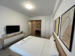 a small room with a bed and a television at Perfect Host Palas Studio Central in Iaşi