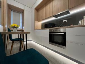 a kitchen with a table and a stove at Perfect Host Palas Studio Central in Iaşi