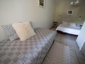 Un pequeño dormitorio con una cama y una cama blanca Sidx Sidx Sidx Sidx. en Ξενώνας ΙΙ σε αγροικία με τζακι, en Kalavrita
