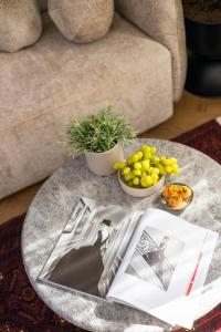 a coffee table with a magazine and fruit on it at Damson - Machne Yehuda Hotel in Jerusalem