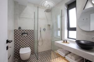 a bathroom with a shower with a toilet and a sink at ELFAM CITY SUITES in Lefkada +78 photos
