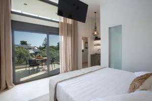 a bedroom with a bed and a large glass window at ELFAM CITY SUITES in Lefkada Town