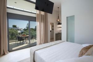 a bedroom with a bed and a large glass window at ELFAM CITY SUITES in Lefkada