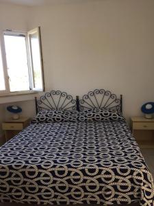 a bedroom with a black and white bed with two windows at L'Isolana Case Vacanza Villa Alessia in Ponza