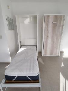 a small bed in a room with a door at Barrancas Al Mar in Puerto Madryn