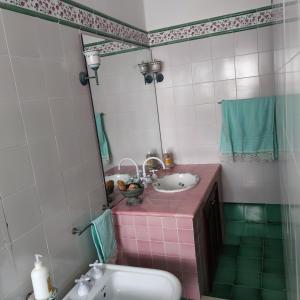 a bathroom with a sink and a mirror at Casa MAIO, attico molto panoramico, in centro storico in Taormina