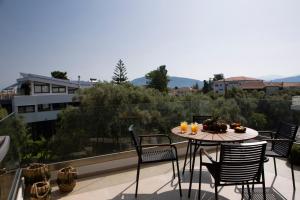a table with a bowl of fruit on top of a balcony at ELFAM CITY SUITES in Lefkada